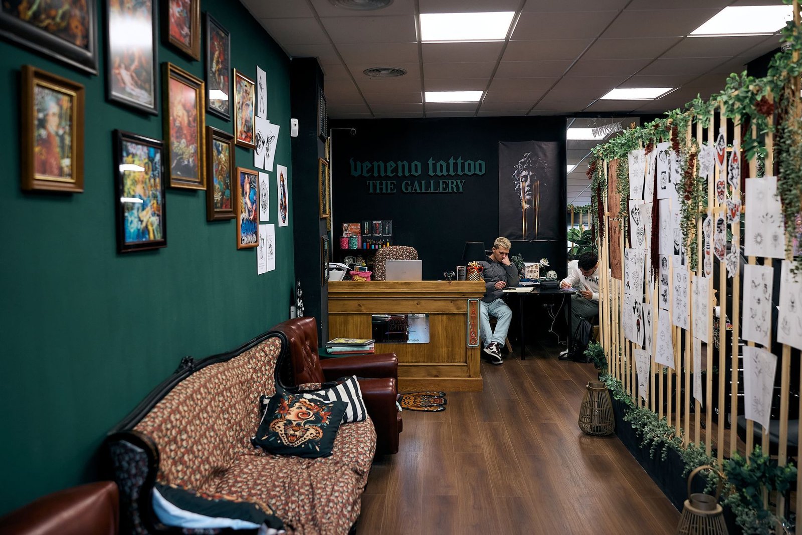 Entrada a un estudio de tatuajes con un letrero de neón que dice 'Veneno Tattoo The Gallery'